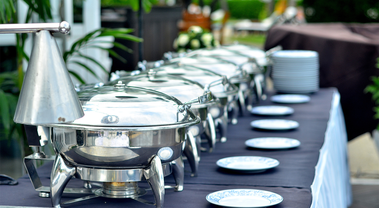 Buffet table with plates and silver serving trays